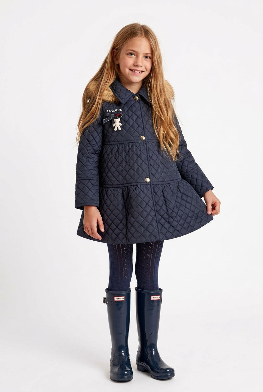 Niña con abrigo Madison acolchado azul marino, medias y botas de agua