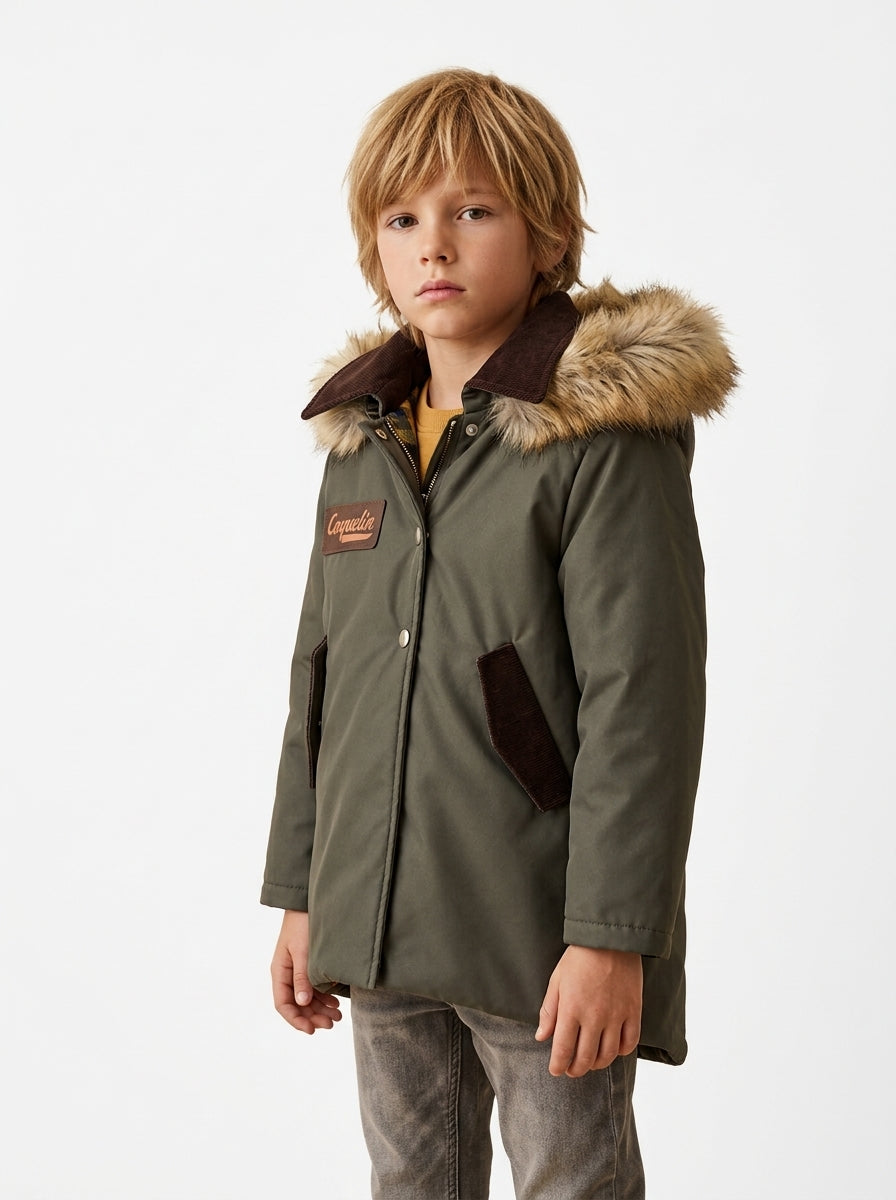 Niño con abrigo Maverick verde caqui y capucha de pelo sintético, cuello marrón y parche personalizado Coquelin, fotografía editorial