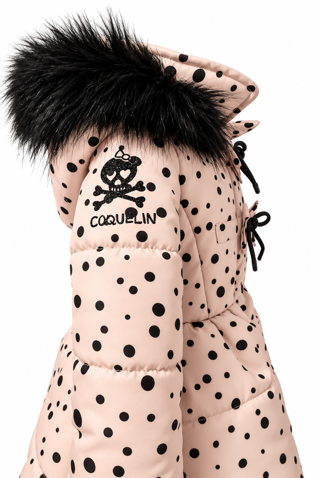 Detalle de manga del abrigo Polka Swing con parche Coquelin negro brillante y capucha de pelo sintético