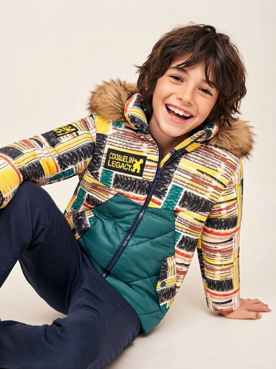 Niño con abrigo Six Seven de Coquelin, estampado de colores y paneles verde petróleo en fotografía editorial